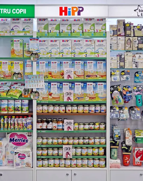 UNGHENI, MOLDOVA - 05 Mart 2024 Eczane raflarında bebek maması, aksesuar ve oyuncaklar depoladı. Bebek için sağlık ürünleri ve ilaçlar