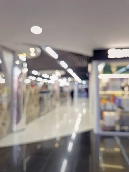 Defocused shopping mall interior. Blurred background of commercial center indoors vie