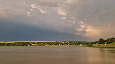 Kırsal bir arazinin üzerinde gökyüzünde şimşekler çakan büyük bir fırtına oluşumu. Şiddetli yağmurdan sonra sağanak. Şiddetli yaz havası çarpıcı patlamalarla