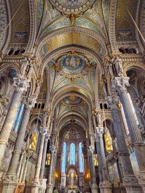 Notre Dame de Fourviere, Lyon, Fransa. Neo-Bizans mimarisi tarzında büyük kemerler, uzun sütunlar, mavi ve altın renkli mozaik tavan, mozaik cam sanat eserleri içeren kapalı bir sunak manzarası.