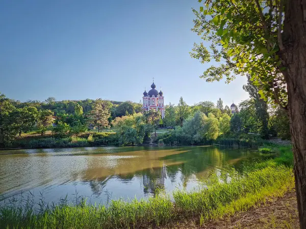 stock image Curchi Monastery with outdoor view near the lake. Christian Orthodox style church traditional for eastern Europe culture located in Orhei, Moldova. Beautiful green gardens with old trees