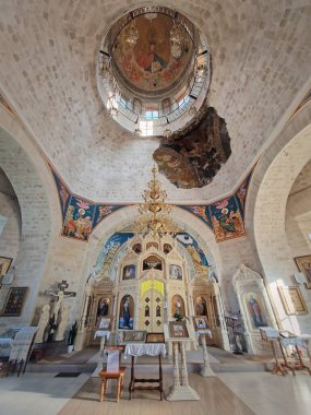 CONDRITA, CHISINAU, MOLDOVA - 21 Ekim 2024 Condrita St. Nicholas Manastırı kilise sunağı manzaralı, boyanmış ikonlar ve altın bir avize ile süslü duvarlar. Geleneksel Hıristiyan Ortodoks