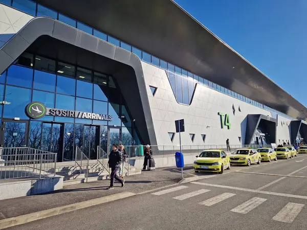 IASI, ROMANIA - 5 Ocak 2025 Modern Iasi havaalanı yeni terminal T4 'ün açık hava görüntüsü. Sarı taksiler ön tarafa park edilmiş.