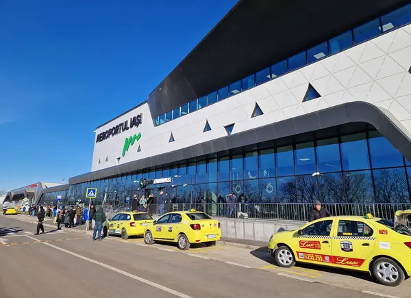 IASI, ROMANIA - 5 Ocak 2025 Modern Iasi havaalanı yeni terminal T4 'ün açık hava görüntüsü. Sarı taksiler ön tarafa park edilmiş.