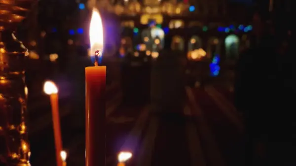 Hıristiyan Ortodoks kilisesindeki şamdanın üzerinde yanan bir mumun yakın çekimi. Alevler keskin ve parlak. Paskalya ya da Noel tatilleri için dini bir sembol. Din ve inanç kavramı