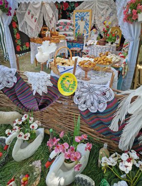 UNGHENI, MOLDOVA - Mayıs 04, 2025 El yapımı fırın ve farklı el sanatları sergisi. Nakışlı tekstil ve dini simgelerle geleneksel Moldova festival düzeni, zengin bir kültürel estetik yaratıyor