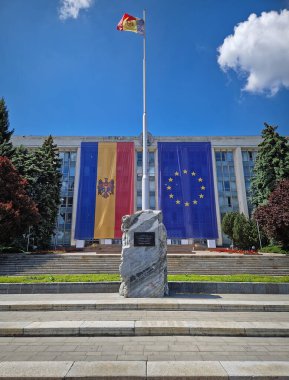 CHISINAU, MOLDOVA - 21 Mayıs 2025 Sovyet İşgali Mağdurları anıtı olan Moldova Hükümet Binası ön cephesinde büyük AB bayrağıyla süslenmiş.