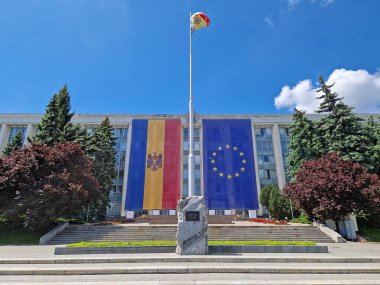 CHISINAU, MOLDOVA - 21 Mayıs 2025 Sovyet İşgali Mağdurları anıtı olan Moldova Hükümet Binası ön cephesinde büyük AB bayrağıyla süslenmiş.