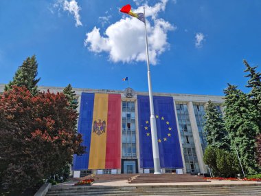 CHISINAU, MOLDOVA - 21 Mayıs 2025 Sovyet İşgali Mağdurları anıtı olan Moldova Hükümet Binası ön cephesinde büyük AB bayrağıyla süslenmiş.