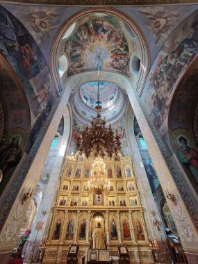 Capriana Manastırı Moldova 'da bulunan geleneksel Hıristiyan Ortodoks kilisesine ev sahipliği yapıyor. İlahi ayin sırasında sunakta dua eden bir keşişle büyük yaldızlı bir avizenin altında