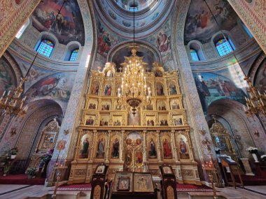 Capriana Manastırı Moldova 'da bulunan geleneksel Hıristiyan Ortodoks kilisesine ev sahipliği yapıyor. İlahi ayin sırasında sunakta dua eden bir keşişle büyük yaldızlı bir avizenin altında