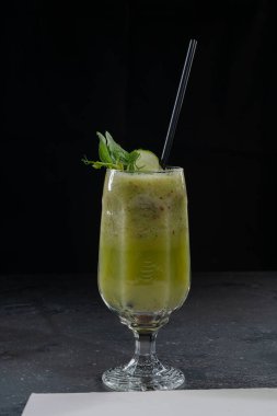Yaz restoranının kokteyl menüsü için salatalıklı ıspanaklı, elmalı ve elmalı buzlu yeşil meyve suyu.