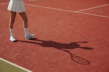 Maç boyunca tenis sahası halısında gölgede kalan oyuncu. Profesyonel olarak tenis oynayan bir kadın. Eğlence için etkinlik. Tenis oyuncusu iş başında.