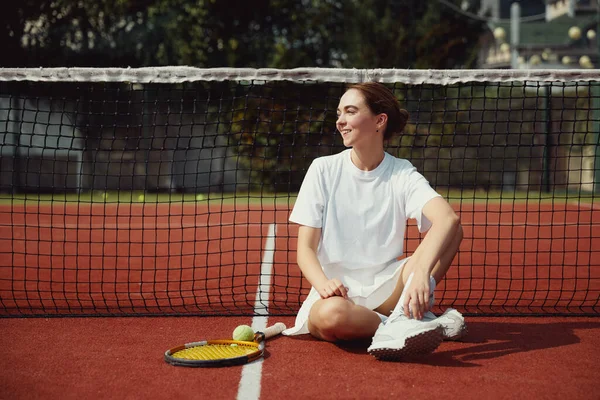 Молодая Женщина Теннисной Ракетке Белой Одежде Сидит Теннисном Корте Рядом — стоковое фото