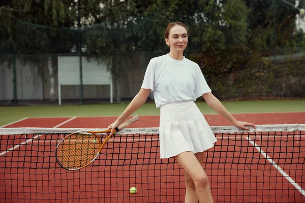 Модная Женщина Белой Одежде Теннисной Ракеткой Позирует Теннисной Сетки Корте — стоковое фото