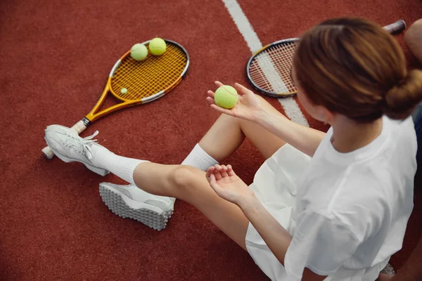 Вид Сверху Молодую Девушку Костюме Сидящую Теннисном Корте Держа Мяч — стоковое фото