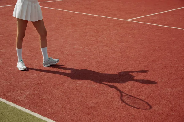 比赛期间 球员的影子出现在网球场的地毯上 一个女人打网球很专业 文娱活动 网球选手在行动 — 图库照片