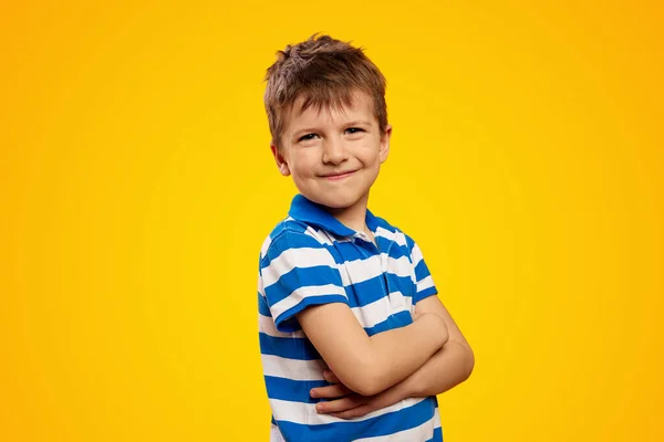 Mały Uroczy Chłopiec Pasiastej Koszuli Stojący Rękami Skrzyżowanymi Żółtym Tle Obrazek Stockowy