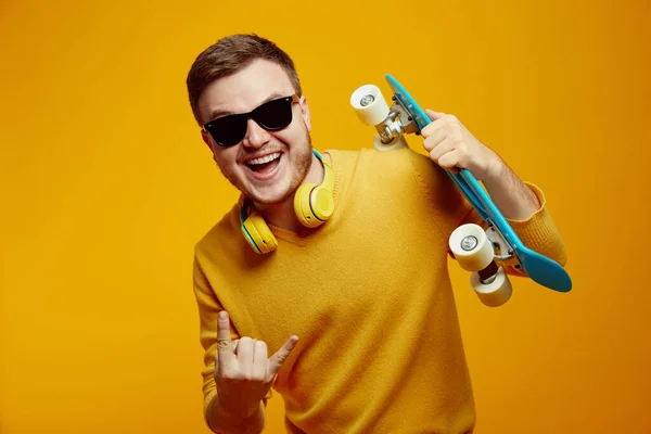 Podekscytowany Mężczyzna Ubrany Żółty Sweter Modne Okulary Przeciwsłoneczne Trzymające Longboard — Zdjęcie stockowe