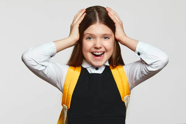 Menina Surpreendida Uniforme Escolar Mochila Amarela Mantendo Mãos Cabeça Gritando — Fotografia de Stock