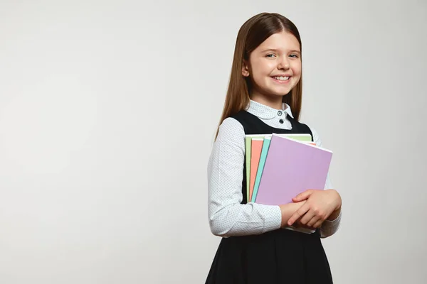 Spennende Jente Skoleuniform Med Fargerike Bøker Mens Hun Smiler Ser – stockfoto