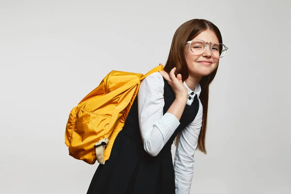 Κουρασμένη Μαθήτρια Φορώντας Στολή Και Γυαλιά Κρατώντας Κίτρινο Σακίδιο Απομονωμένη — Φωτογραφία Αρχείου