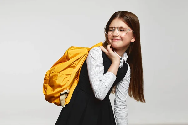 Κουρασμένη Μαθήτρια Φορώντας Στολή Και Γυαλιά Κρατώντας Κίτρινο Σακίδιο Κοιτάζοντας — Φωτογραφία Αρχείου