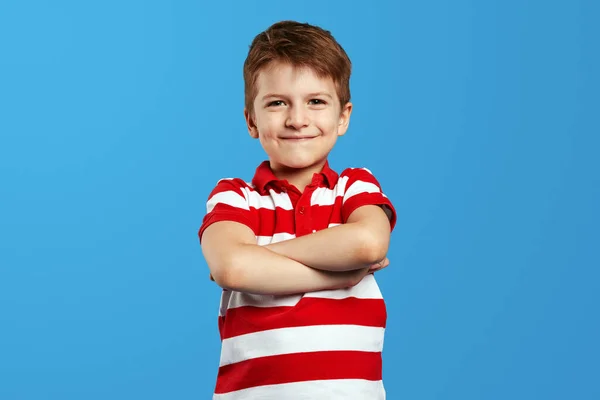 身穿红色条纹衬衫的可爱小男孩手挽手 站在蓝色的背景下看着相机 — 图库照片