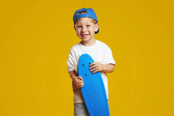 Szczęśliwy Chłopiec Białej Koszulce Niebieskiej Czapce Trzymając Longboard Uśmiechając Się — Zdjęcie stockowe