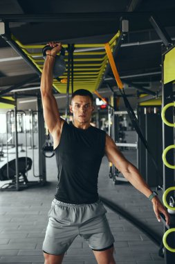 Genç sporcu antrenman için kettlebell kullanıyor. Kafkas sporcusu. Güçlü, sağlıklı, kaslı. Ağır spor aletleri kullanıyor. Vücut geliştirme için yaşam stili olarak beden eğitimi.