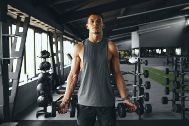 Kafkas erkek atletizm antrenmanı. Spor salonunda halterli pazı kasları. Sağlık ve sağlık konsepti için ağırlık çalıştırma egzersizi. Spor salonunda vücut geliştirici egzersizi.