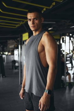 Spor salonundaki antrenmandan sonra beyaz bir erkek sporcunun portresi. Odaklanmış bir jimnastik koçu spor giyim bölümünde kameraya özgüvenle bakıyor..