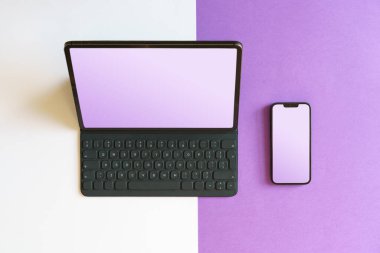 Laptop ve akıllı telefon. Boş ekran modeli. Akıllı aletler. Renkli arkaplan.