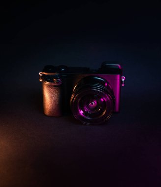 Karanlık arka planda fotoğraf makinesi. Neon ışıkları. Fotoğraf dişlisi kopyalama alanı. 