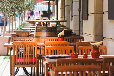 Büyük bir Avrupa şehrinin merkezinde bir restoranın açık masaları. Şarap fıçısı..