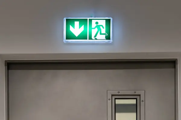 Emergency exit sign in an office building. Underground garage.
