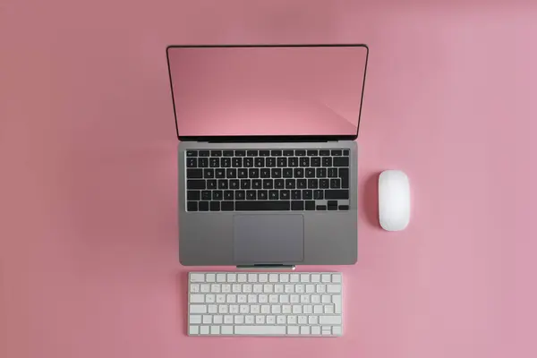 Laptop with keyboard and mouse. Pink Peach background. Empty clean screen mockup. Pink color details.