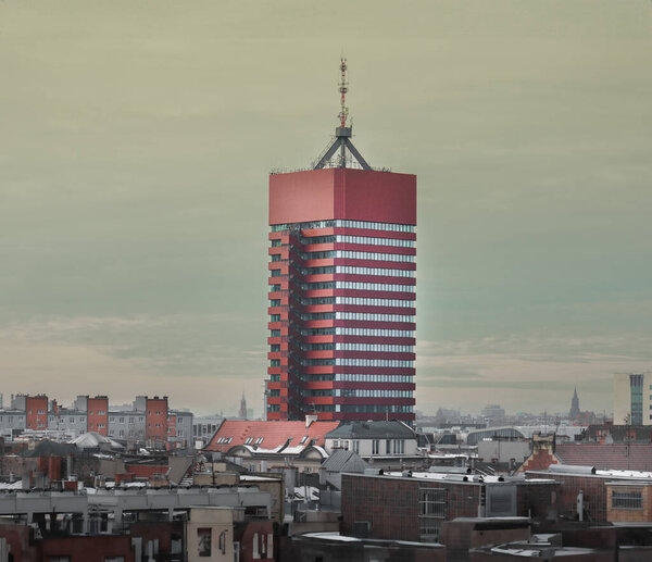 Red tall office building in city center. Geometric shapes architecture. Poznan cityscape.