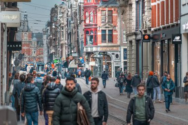 Amsterdam, Hollanda, 13 Mart 2024. Öğlen şehir merkezinde. Dükkanları ve restoranları olan kalabalık bir cadde..