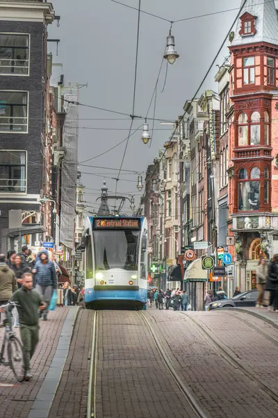 Amsterdam, Hollanda, 13 Mart 2024. Şehir tramvay durağı. Toplu taşıma. Dükkanları ve restoranları olan kalabalık bir cadde..