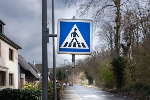 Road sign, pedestrian crossing. Street in a housing estate. German traffic sign.