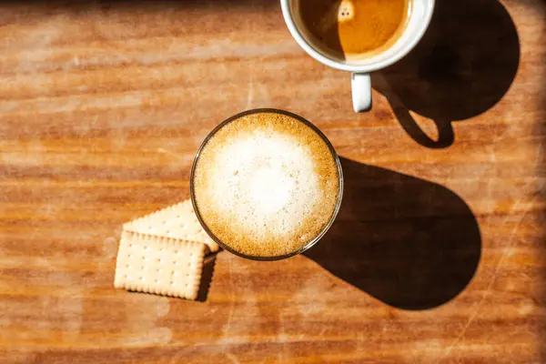 stock image Glass with vegan grain coffee and plant milk. Natural biscuits. Wooden table top view.