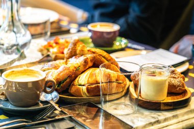 Kahvaltı oteli restoran masası. Sabah toplantısı. Parma jambonlu sandviç. Kahve fincanı.