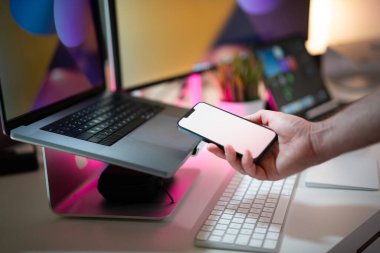 El ele tutuşan akıllı telefon boş beyaz ekran modeli. Ev stüdyosu içi..