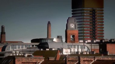 Saat kulesi ve zaman geçiyor. Şehir mimarisi işte. Momentum değişimi kırmızı tuğla gökdelen.