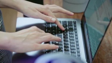 Dizüstü bilgisayarda klavye. Ev yapımı ahşap masa, yeşil bitkiler. Bilgisayar mühendisi ofis ekipmanları.