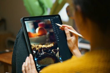 Dijital grafik tablet deniz feneri yazılımında kadın fotoğraf düzenleme evde oturma odasında iç mekanda yaratıcı iş