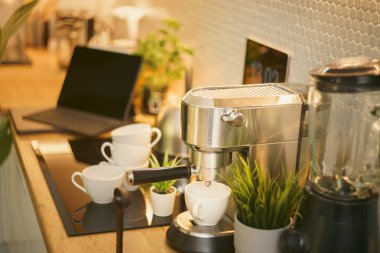 Modern ev restoranı mutfak masa saati espresso kahve fincanı sergiler.