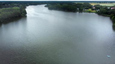 Polonya Gölü Yaz Tatil Ormanı Kıyı İnsansız Hava Aracı Manzarası. Yaz boyunca Polonya kırsalının yukarısından görülen yeşil orman kıyıları, park halindeki arabalar ve kayaklarla Avrupa 'da sakin bir göl..