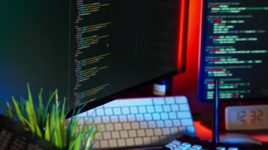 Klavye, bitki dekoru ve parlayan ekranlarla modern çalışma alanı içeren ev tipi ofis renk aydınlatma ayarları. Yazılım gelişimini, teknoloji endüstrisini, dijital yaşam tarzı bilgisayar ekipmanlarını temsil eden soyut çekim